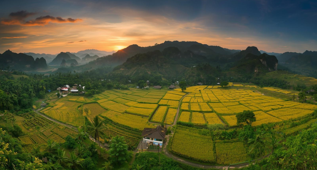 Aerial view of Perlis at sunset with limestone hills, paddy fields, and traditional village houses, showcasing serene landscapes, nature travel, and cultural experiences in Malaysia.